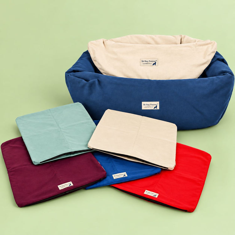 Organic cotton replacement dog bed covers in Sea Mist, Natural, Plum, Denim and Red, with a round bolster bed