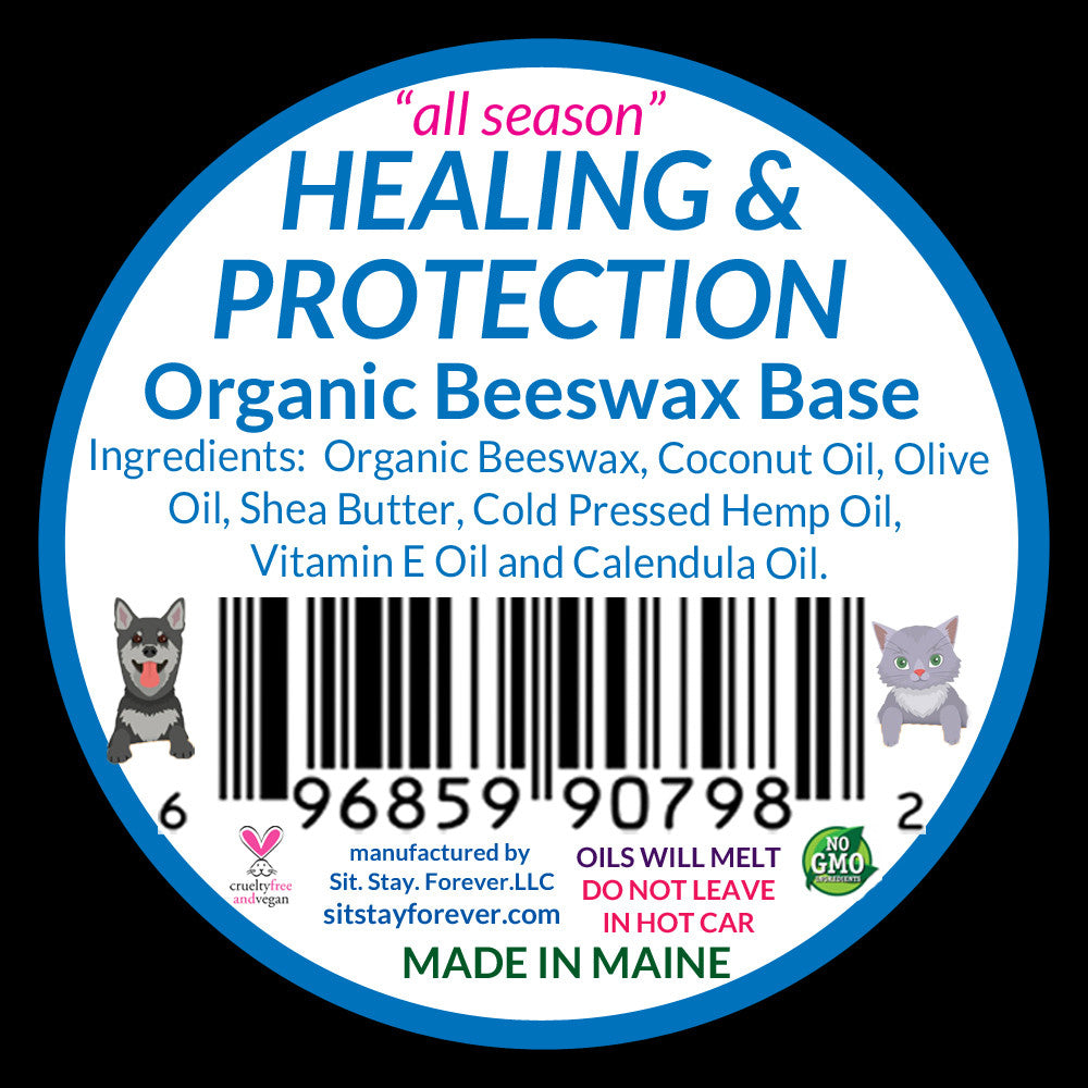 The back label of the "Sit.Stay.Forever. paw salve" tin showing the ingredients list and product details. The label includes the text "HEALING & PROTECTION," and lists ingredients like Organic Beeswax, Coconut Oil, Olive Oil, and more. It also includes a barcode and small illustrations of a dog and a cat.