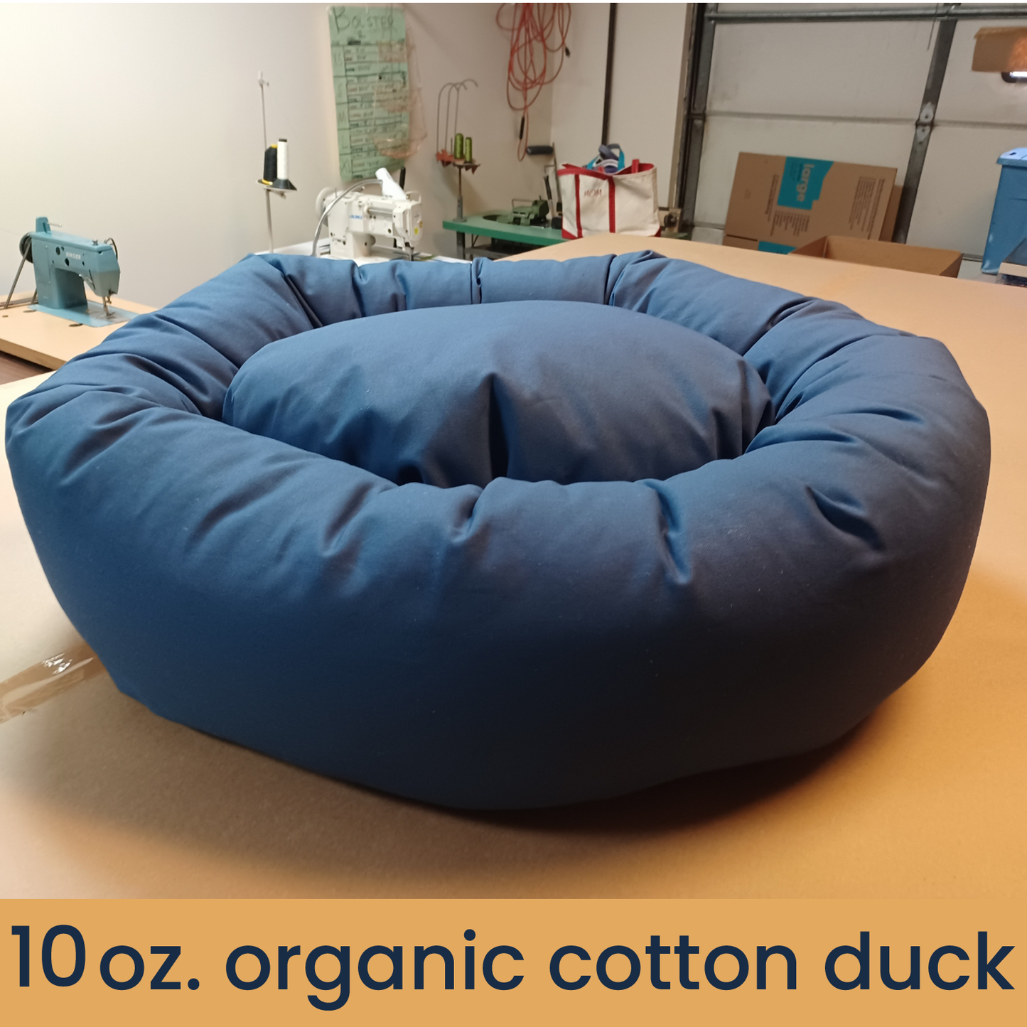 denim colored organic cotton dog bed sitting on top of cutting table 