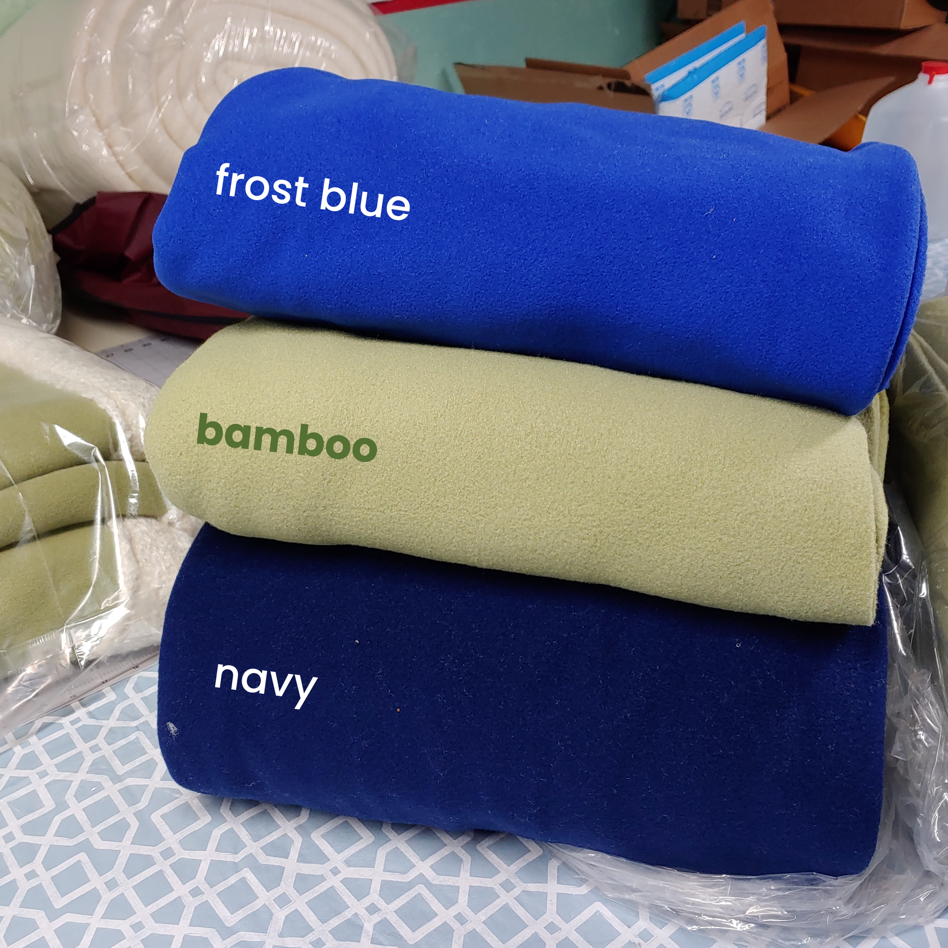 folded piles of frost blue, bamboo and navy colored polartec 300 double velour fabric