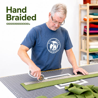 Man cutting fabric with a ruler on a cutting mat, with 'Hand Braided' text above.
